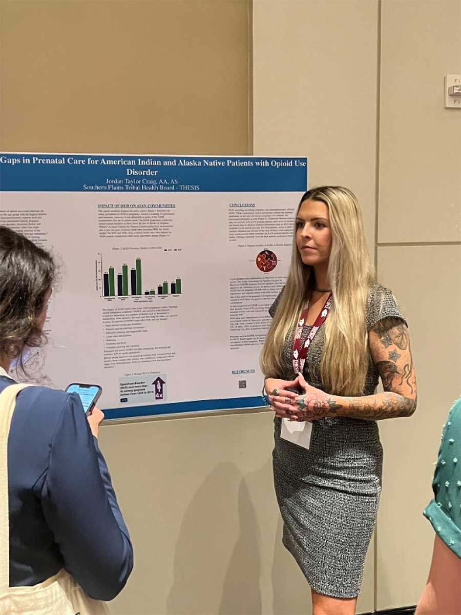 Jordan Craig, a member of the Cherokee Nation, answers questions over her poster presentation, “Addressing Gaps in Prenatal Care for American Indian and Alaska Native People with Opioid Use Disorder.”